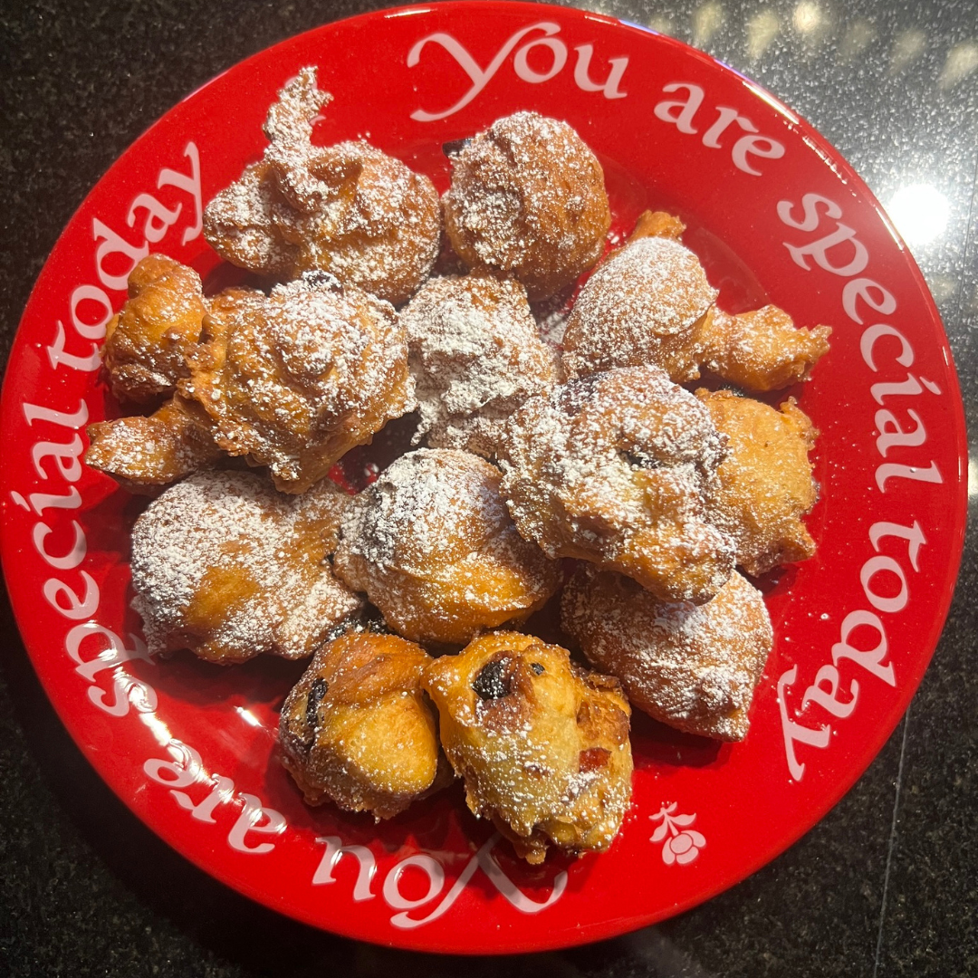 Red Plate with the words "You aer special today" around the rim, filled with oliebollen sprinkled with powdered sugar.